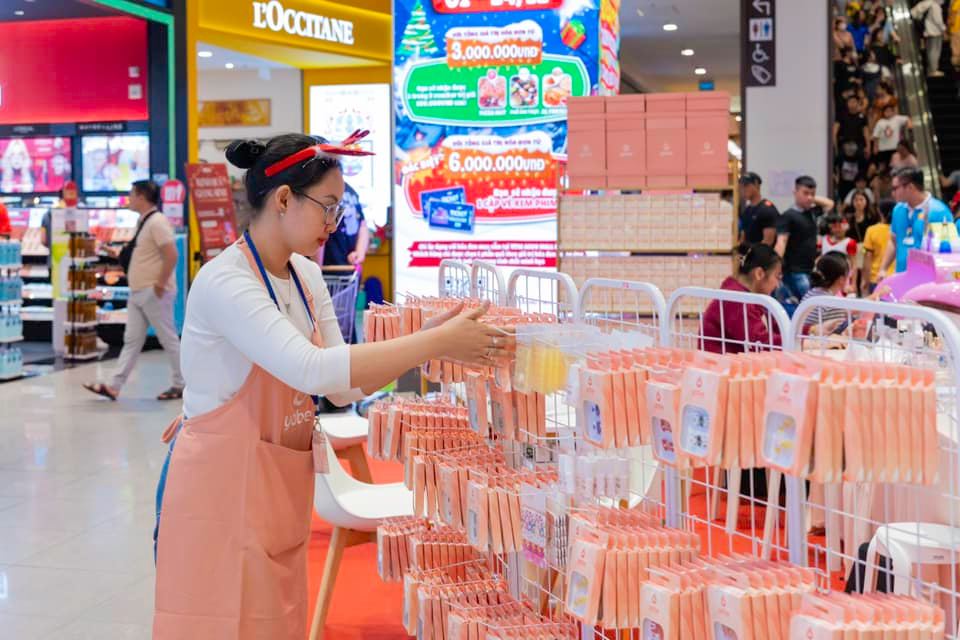 Why Choose Yabe as Your Leading Handmade Press-on Nail Distributor? 6 A woman in an apron standing in front of a display of small items